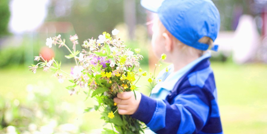 En blombukett som hålls av ett barn.